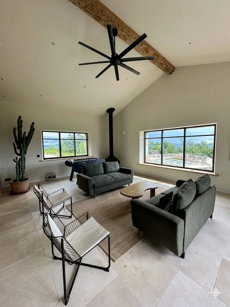 Salon sous la charpente, cactus et vue sur la piscine